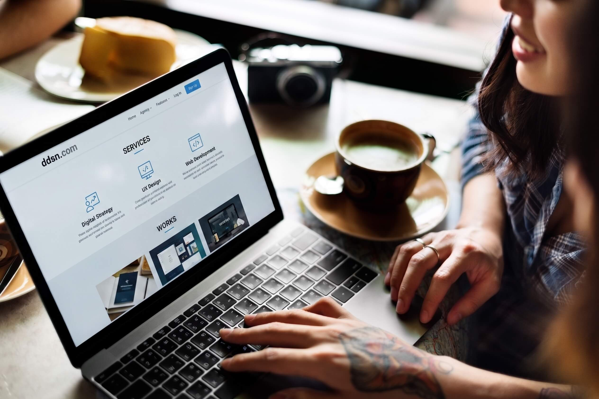 woman interacting with laptop in a cafe, reviewing a website. photo modified with AI to replace the website.